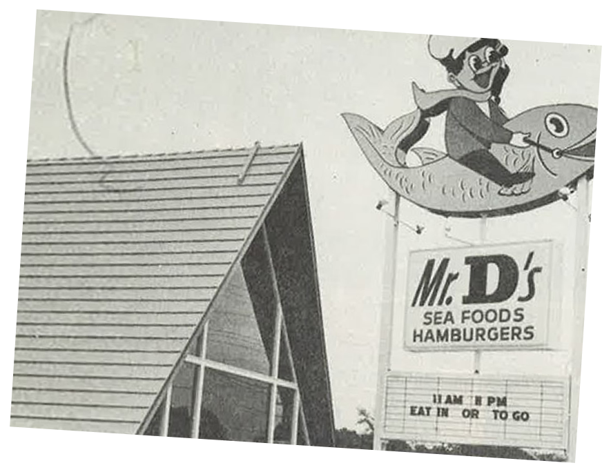 Image of the first Mr. D's Seafood and Hamburgers store and sign, featuring a cartoon of a kid riding a fish.