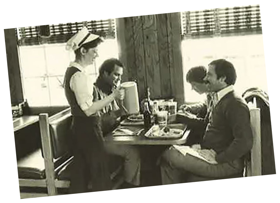Image of a waitress serving beverages to a table of Captain D's customers.